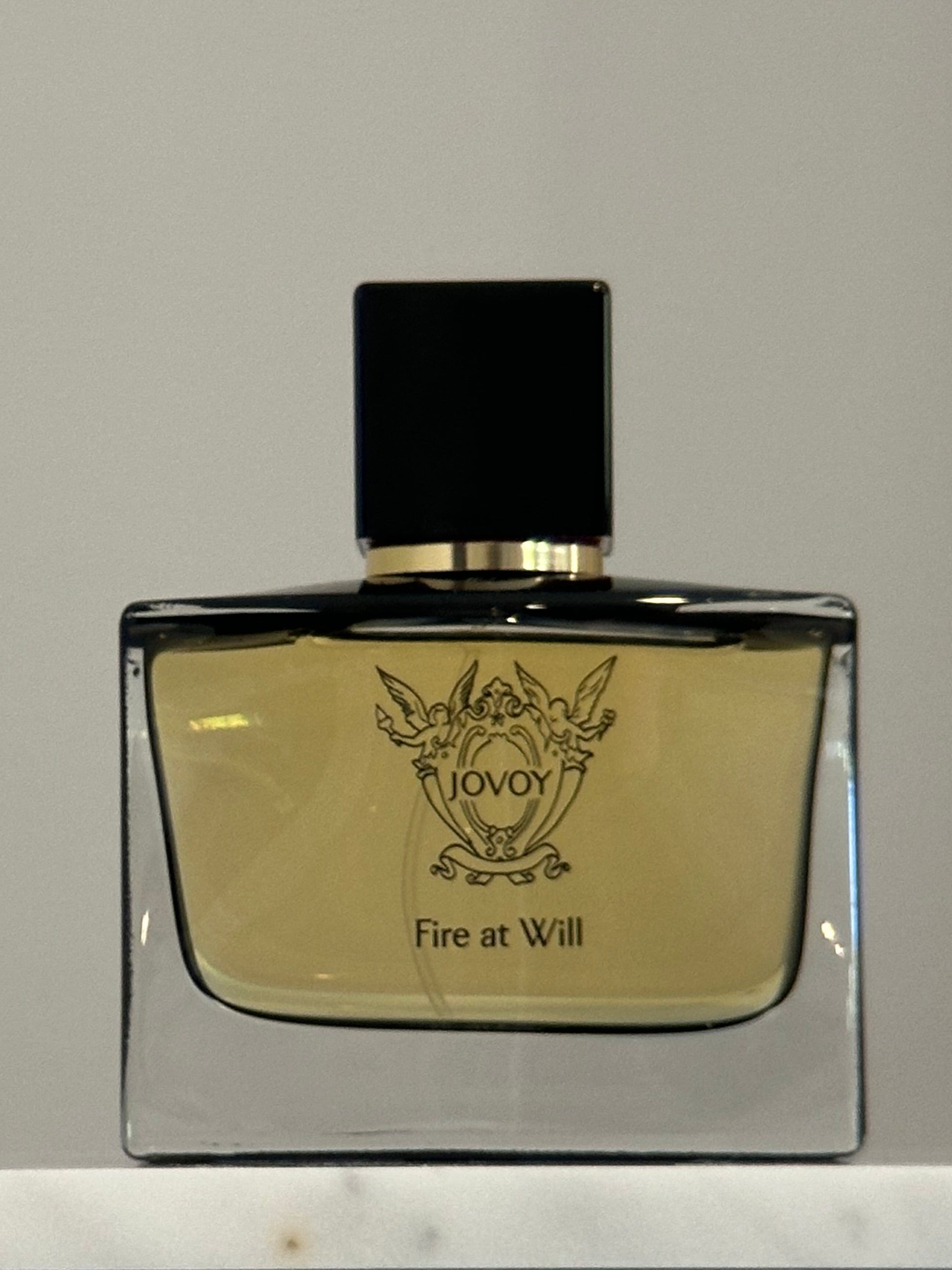 Perfume bottle with a gold label on a neutral background
